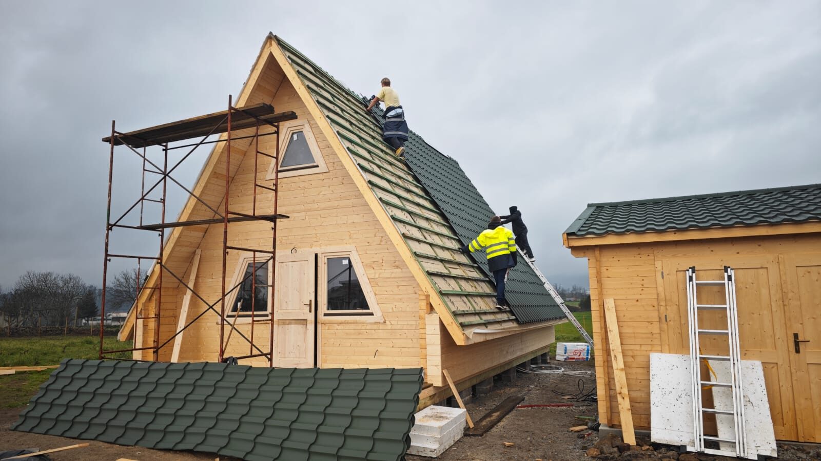 Equipa MF a aplicar a telha verde na cobertura da casa A-Frame