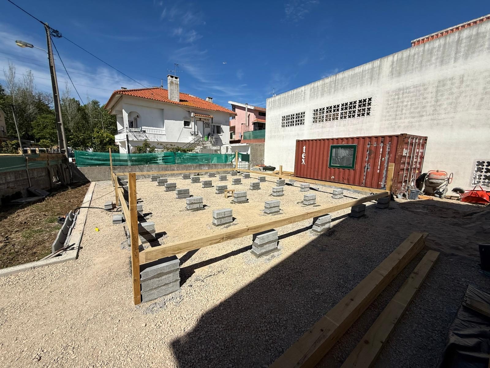 Terreno regularizado com brita, pilares de fundação em blocos de betão e vigas de bordadura em madeira tratada da Villa T4
